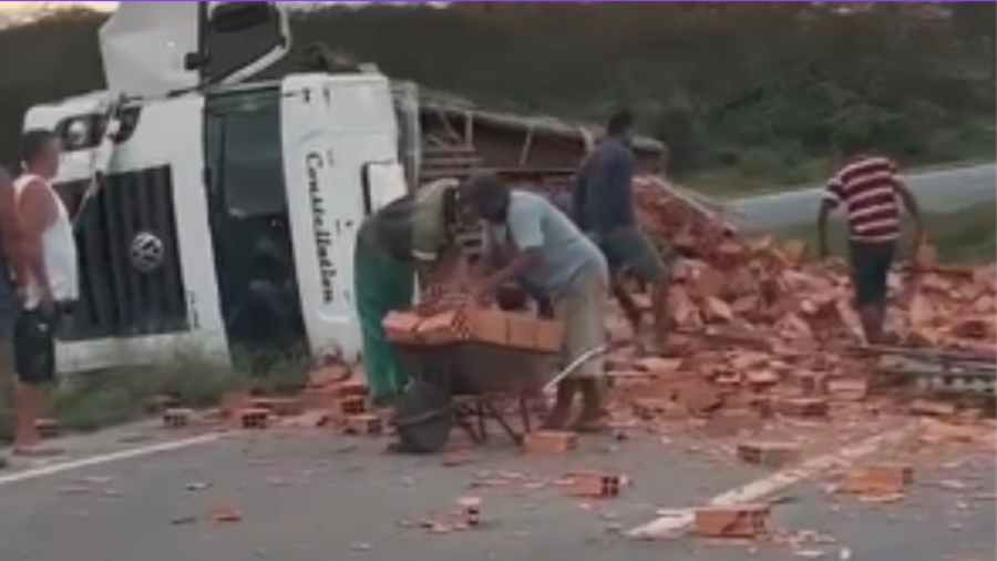 Caminhão carregado de blocos tomba na BR-324 e moradores saqueiam carga na Bahia